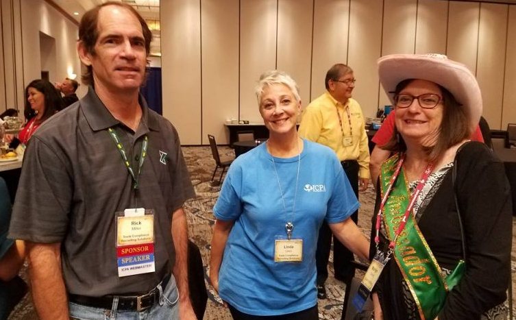 Volunteers and attendees talking in an ICPA conference ballroom, one in a volunteer shirt and one wearing an ambassador sash