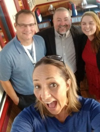 Four ICPA volunteers crowded into a group selfie away from the conference floor